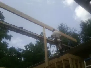 Carpenter setting a ridge beam over a new addition frame — Ice Dam Removal by Roofing Brothers in University Place