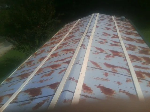 Rusted metal roof panels with new wood purlins before replacement — Storm Damage Roof Repair in University Place by Roofing Brothers